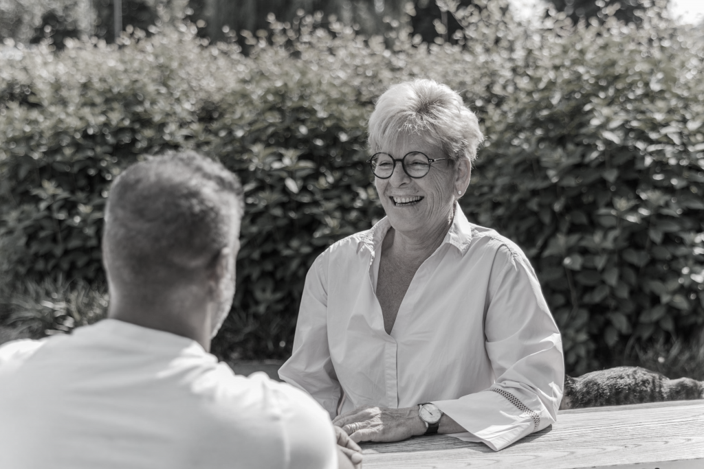 Cliënt lachend in gesprek met coach Remy